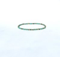 A boho beaded bracelet strung on transparent stretch cord using medium-sized Japanese miyuki glass beads in turquoise, dark teal and gold color