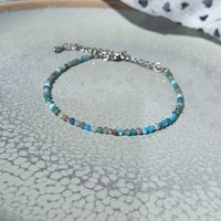 Thin agate bracelet in shades of light blue and gray with tiny silver-plated beads, stainless steel lobster claw clasp