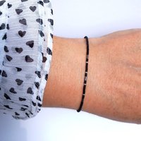 Thin miyuki stretch bracelet of tiny rocaille beads in black and silver color, minimalist style, light, seed beads