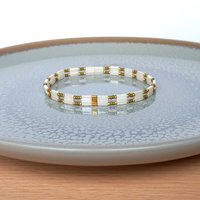 Elegant Japanese miyuki glass beads bracelet strung on transparent stretch cord - comfortable enough to wear every day yet elegant in a subtle way.  Two strands with white tila beads and the tiniest size rocailles in golden olive green and gold color  Wear alone for an understated minimalist look or add to your bracelet stack for a boho look  All our jewellery is handmade with care and attention to detail in Amsterdam, The Netherlands. This bracelet is made to order at your size 