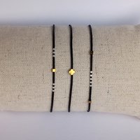 Thin miyuki stretch bracelets with matte black, pearl-white and bronze color tiny beads, three designs in minimalist style