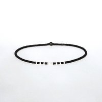 A thin minimalist style miyuki stretch bracelet in matte black and silverlined white