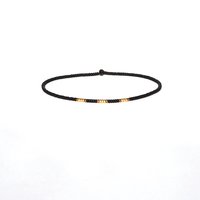 A thin minimalist style miyuki stretch bracelet in matte black, silver and bronze color