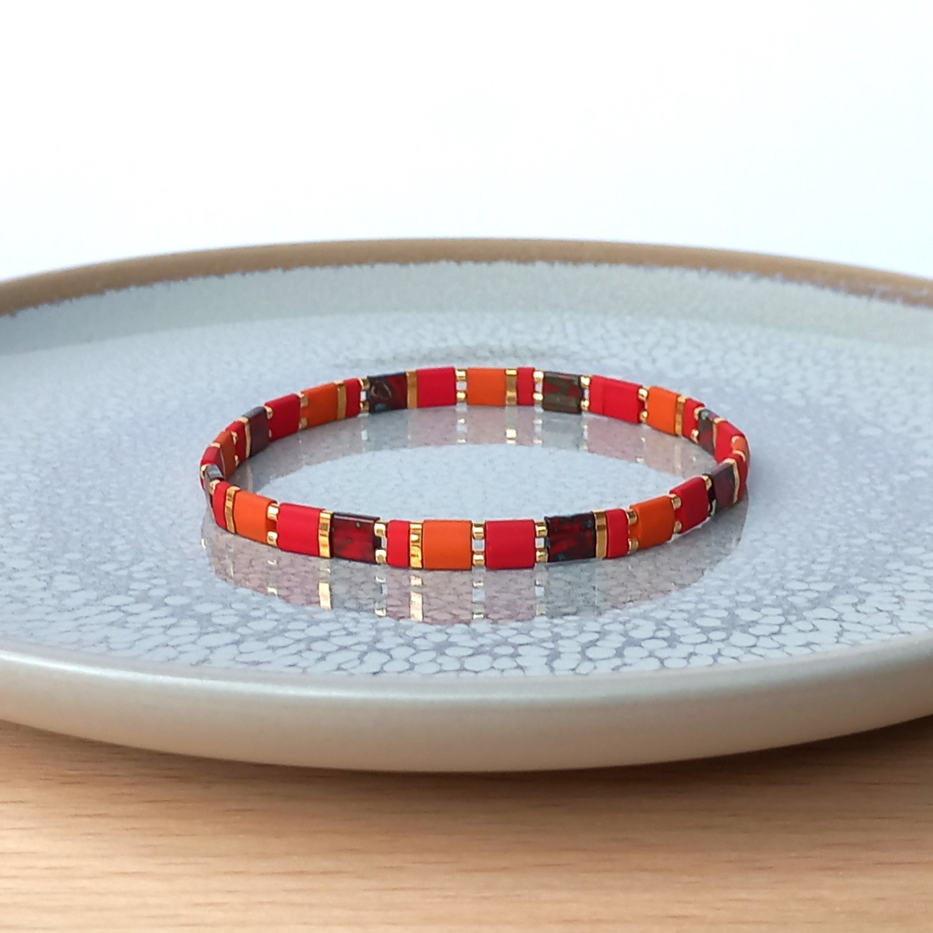 Elegant miyuki tila beads bracelet strung on two strands of transparent stretch cord with dark red, picasso red, terracotta orange and gold-plated tila beads.  Handmade with care and attention to detail and made to order at your size  Available sizes (length): 15cm (5.9in), 16cm (6.3in), 17cm (6.7in), 18cm (7.1in) - make your choice from the drop-down menu when you order.