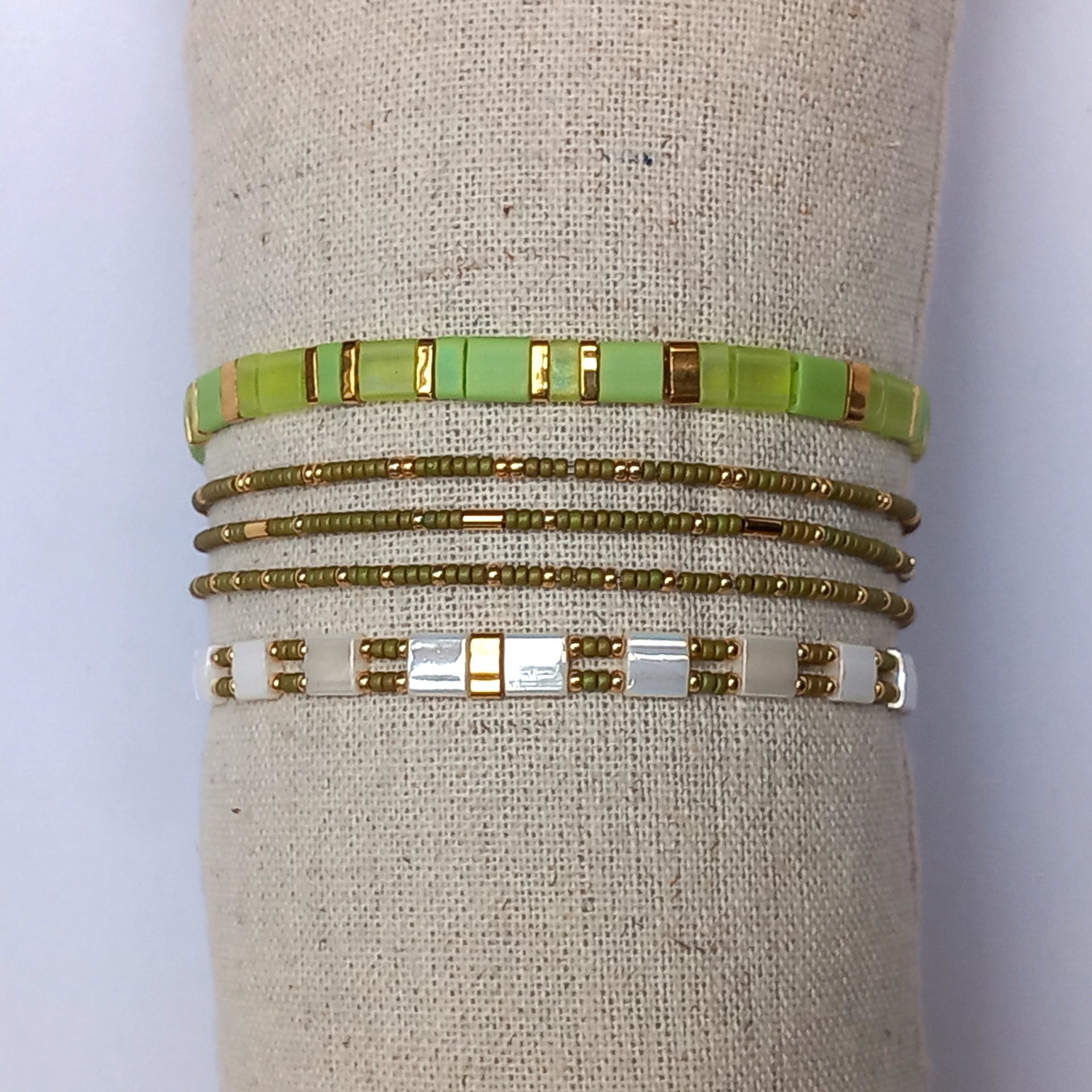 Elegant Japanese miyuki glass beads bracelet strung on transparent stretch cord - comfortable enough to wear every day yet elegant in a subtle way.  Two strands with white tila beads and the tiniest size rocailles in golden olive green and gold color  Wear alone for an understated minimalist look or add to your bracelet stack for a boho look  All our jewellery is handmade with care and attention to detail in Amsterdam, The Netherlands. This bracelet is made to order at your size.