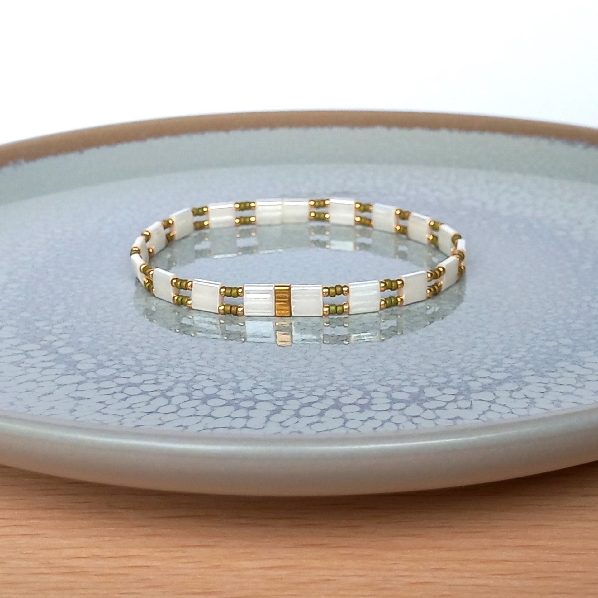 Elegant Japanese miyuki glass beads bracelet strung on transparent stretch cord - comfortable enough to wear every day yet elegant in a subtle way.  Two strands with white tila beads and the tiniest size rocailles in golden olive green and gold color  Wear alone for an understated minimalist look or add to your bracelet stack for a boho look  All our jewellery is handmade with care and attention to detail in Amsterdam, The Netherlands. This bracelet is made to order at your size 