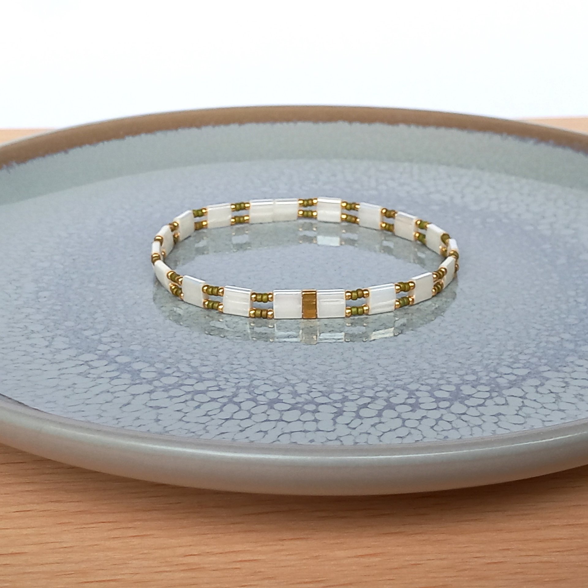 Elegant Japanese miyuki glass beads bracelet strung on transparent stretch cord - comfortable enough to wear every day yet elegant in a subtle way.  Two strands with white tila beads and the tiniest size rocailles in golden olive green and gold color  Wear alone for an understated minimalist look or add to your bracelet stack for a boho look  All our jewellery is handmade with care and attention to detail in Amsterdam, The Netherlands. This bracelet is made to order at your size.