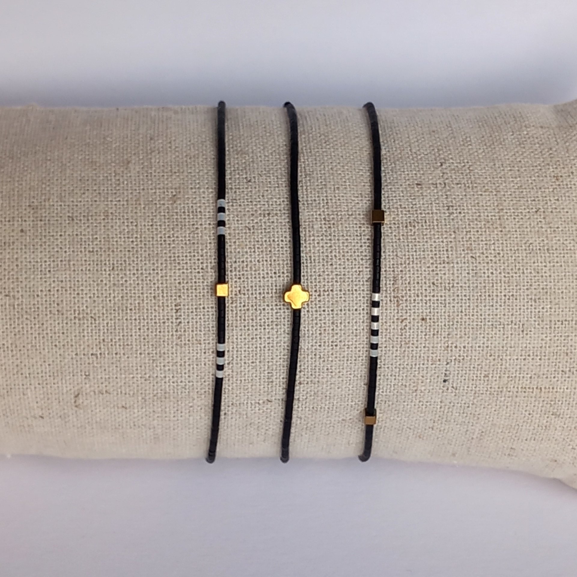 Thin miyuki stretch bracelets with matte black, pearl-white and bronze color tiny beads, three designs in minimalist style