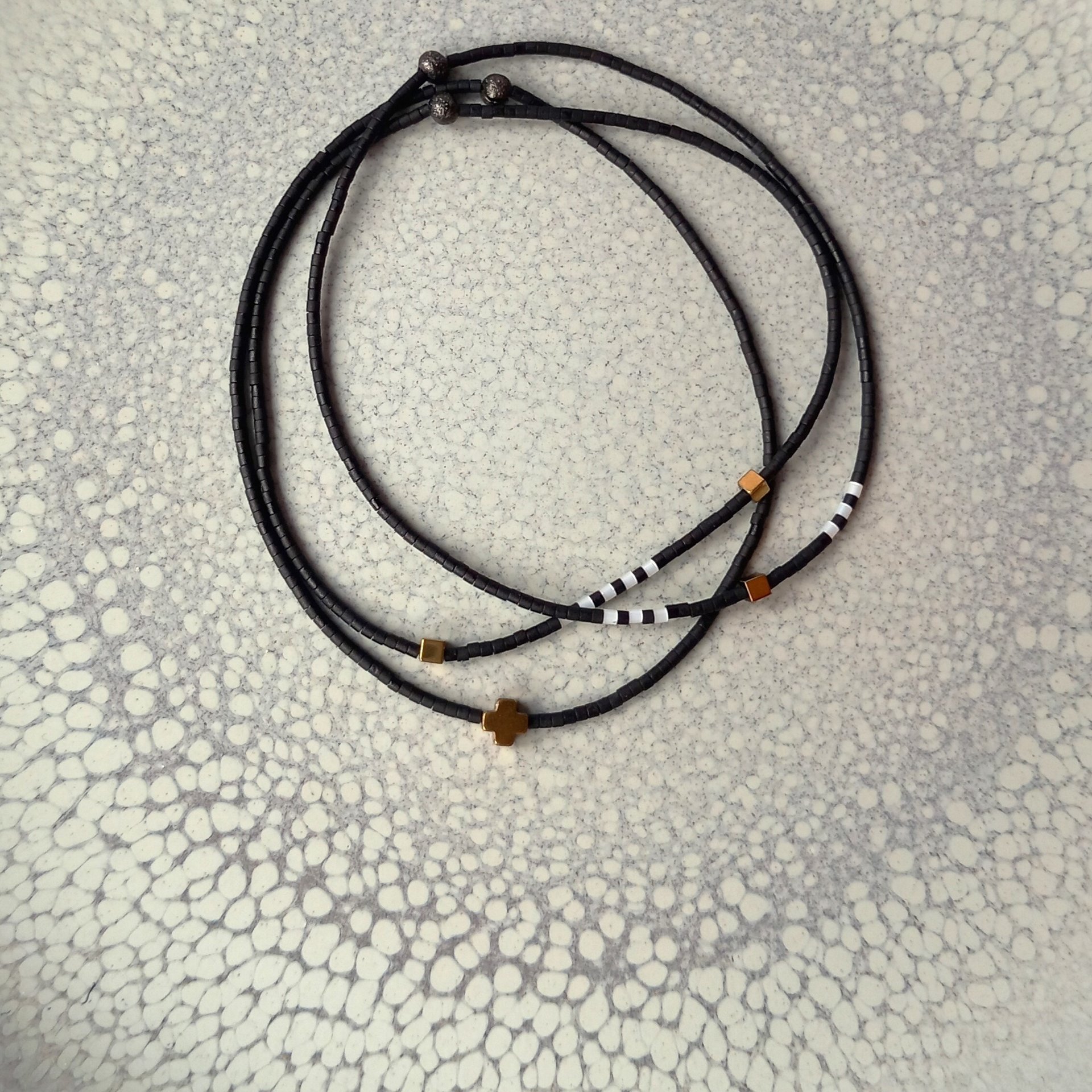 Thin miyuki stretch bracelets with matte black, pearl-white and bronze color tiny beads, three designs in minimalist style