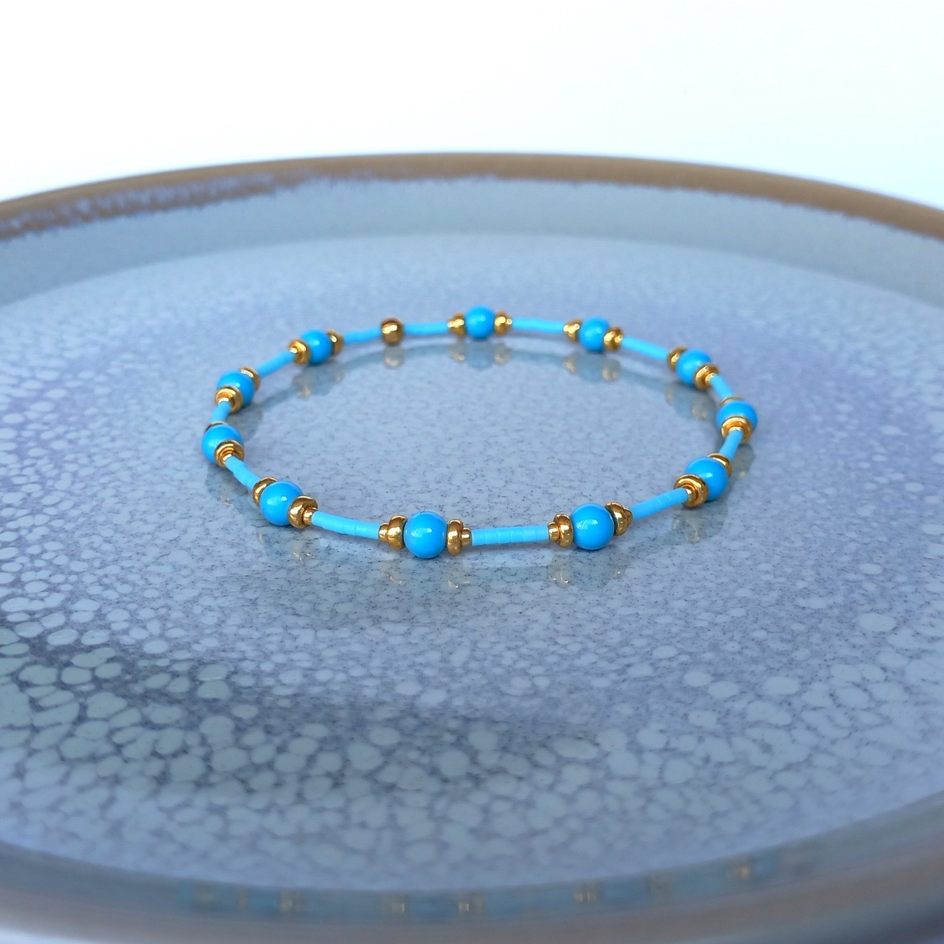 Thin miyuki stretch bracelets with blue crystal pearls, matte tiny glass beads and gold color beads, two designs in minimalist style