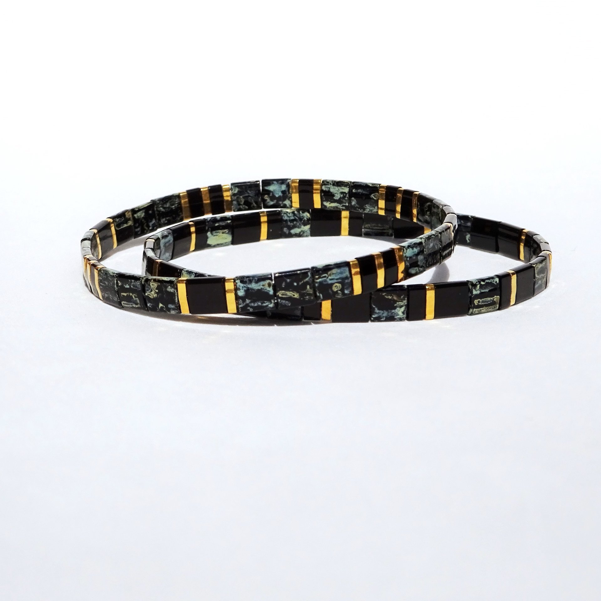 Elegant miyuki tila beads bracelet set strung on transparent stretch cord - Two matching designs with black and gold-plated tila beads 