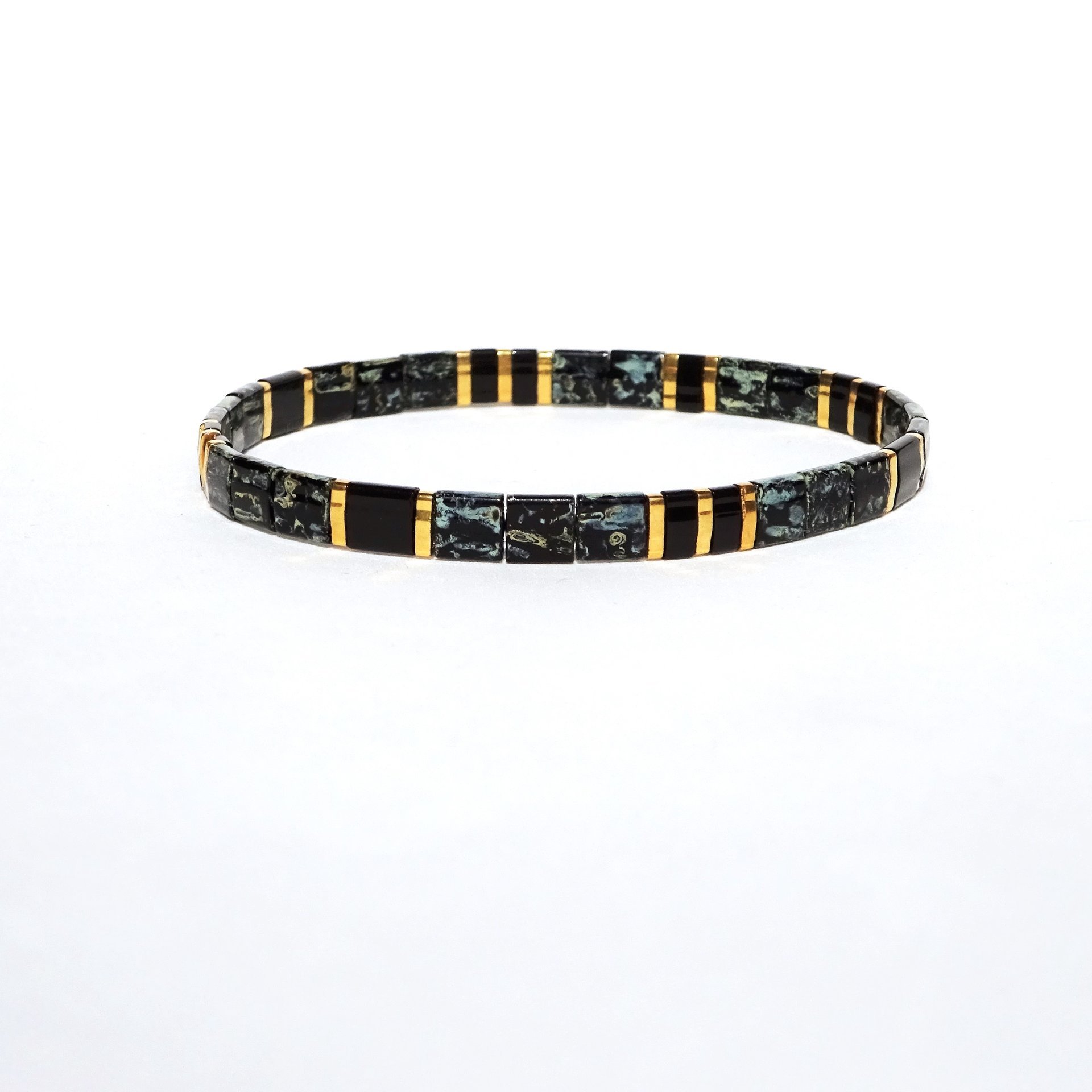 Elegant miyuki tila beads bracelet strung on transparent stretch cord with black and gold-plated tila beads